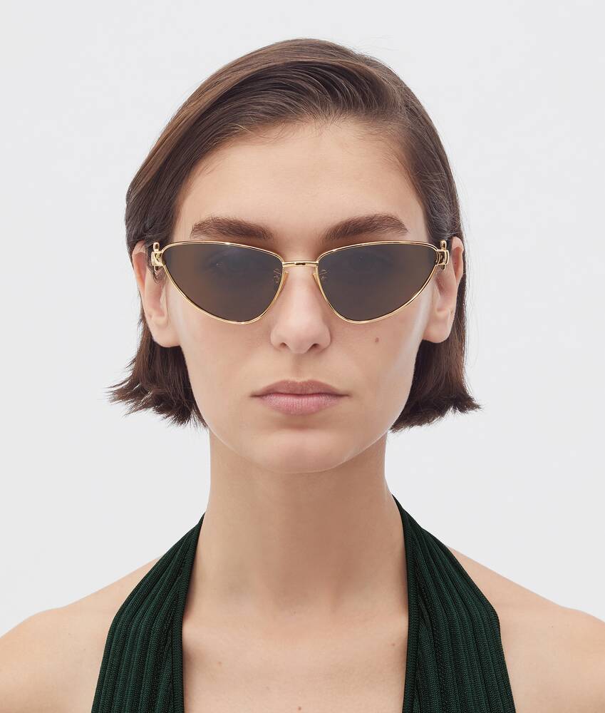 Bottega Veneta® Turn Cat-Eye Sunglasses in Gold / Brown. Shop online now.