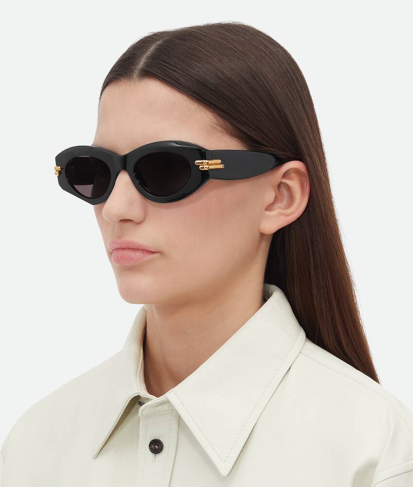 Bottega Veneta Mitre Oval Sunglasses in Black grey. Shop online now